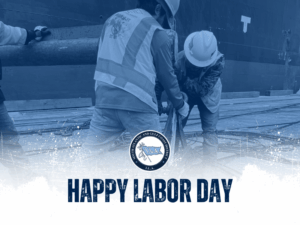 Two ILA workers handling breakbulk behind Happy Labor Day text